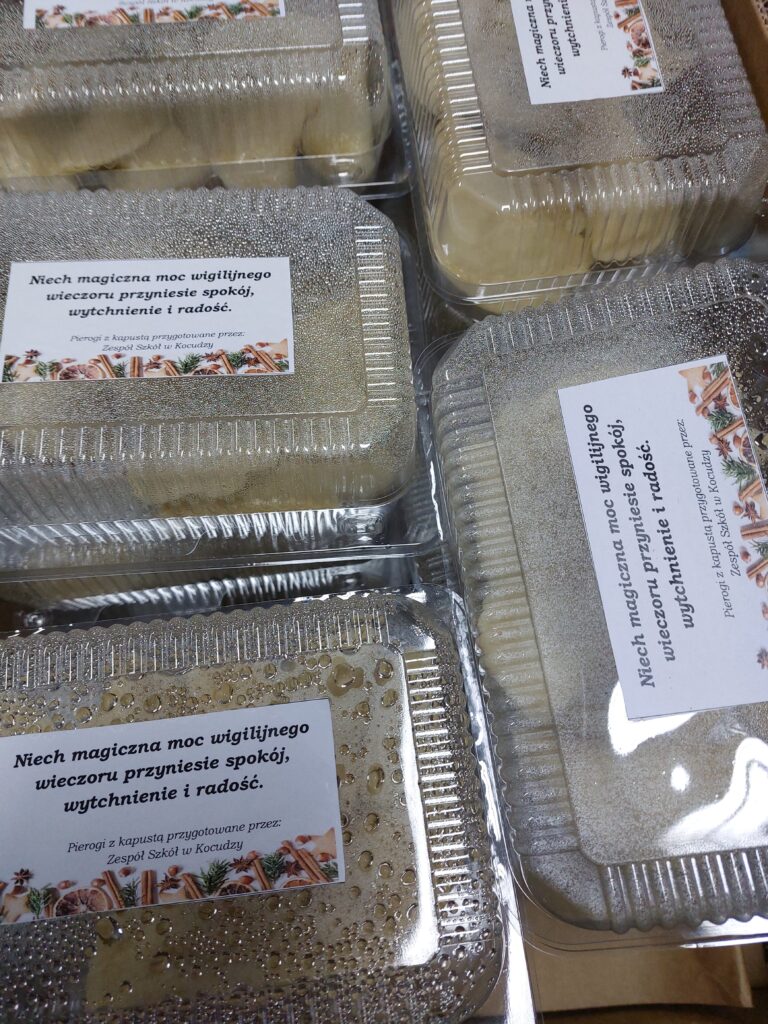 Przezroczyste plastikowe pojemniki z parującą pokrywą i naklejkami z napisem w języku polskim oraz dekoracją z przypraw i ziół.