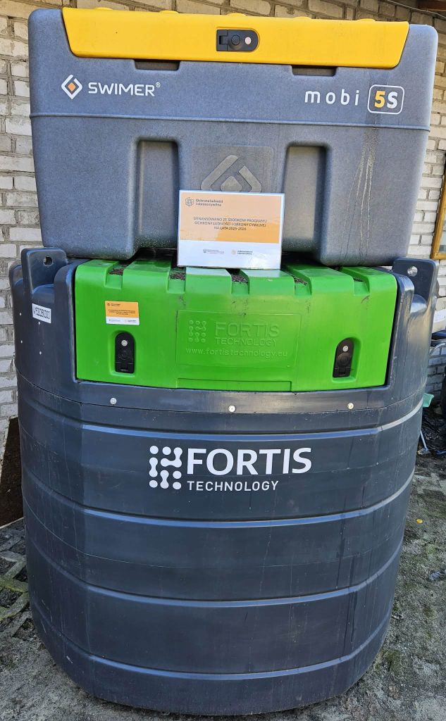 Duży pojemnik z plastikową obudową w kolorach szarym, żółtym, zielonym i czarnym z napisem Fortis Technology na czarnej części.